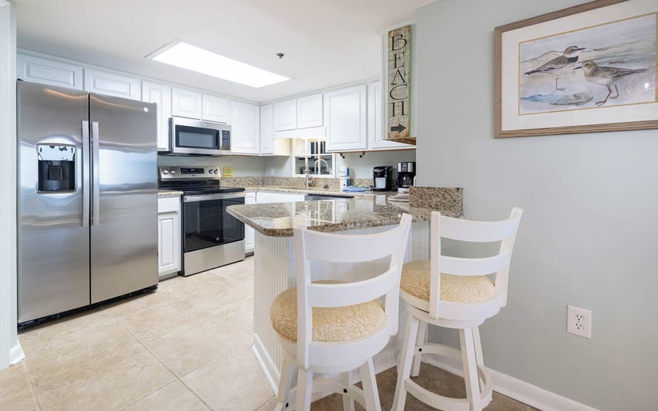 Enjoy cooking in this bright kitchen featuring stainless appliances and a cozy breakfast bar