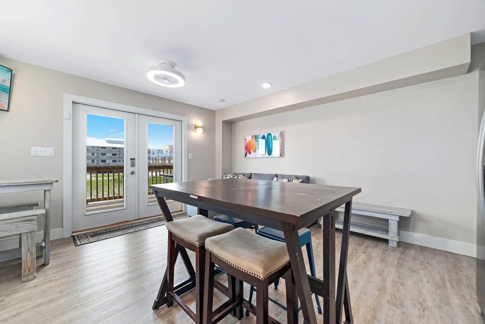 Dining area features a modern table, cozy seating, and access to a scenic outdoor patio
