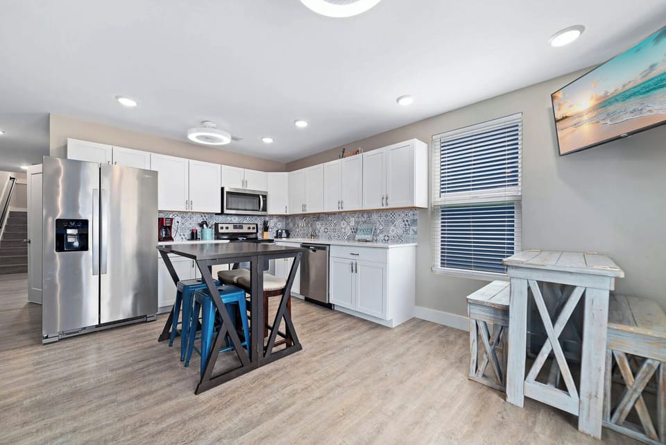 Kitchen featuring stainless appliances, stylish blue stools, and a cozy dining area for memorable meals