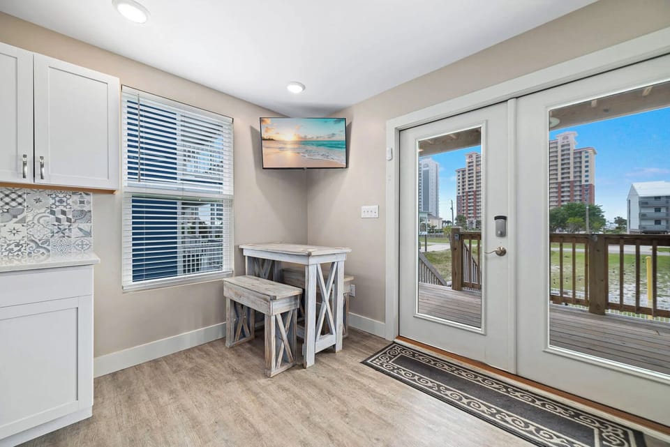 Cozy breakfast nook with a rustic table, a TV, and patio doors leading to a lovely outdoor view