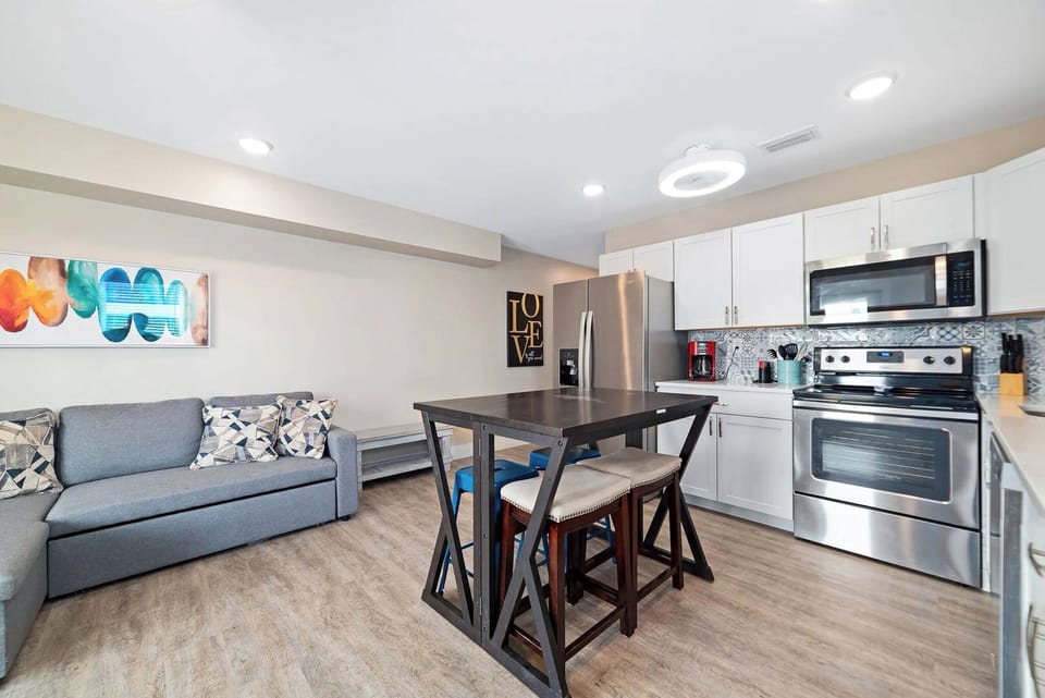 Inviting kitchen with stainless appliances, a cozy dining area, and modern decor, perfect for family gatherings