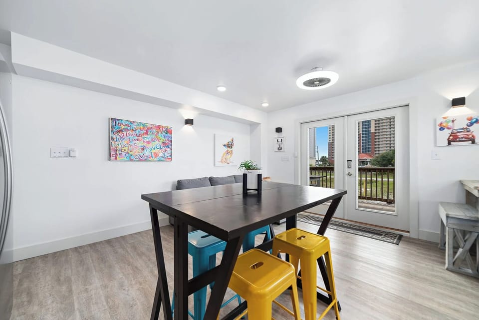 Inviting dining area featuring colorful stools, modern decor, and patio doors leading to a scenic outdoor view