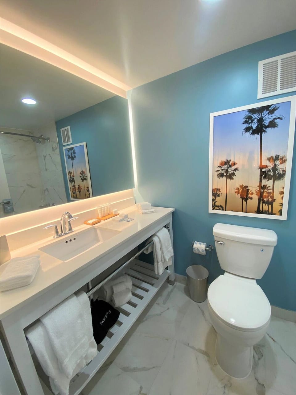 Refresh easily with a glowing mirror, fresh towels, and spacious vanity