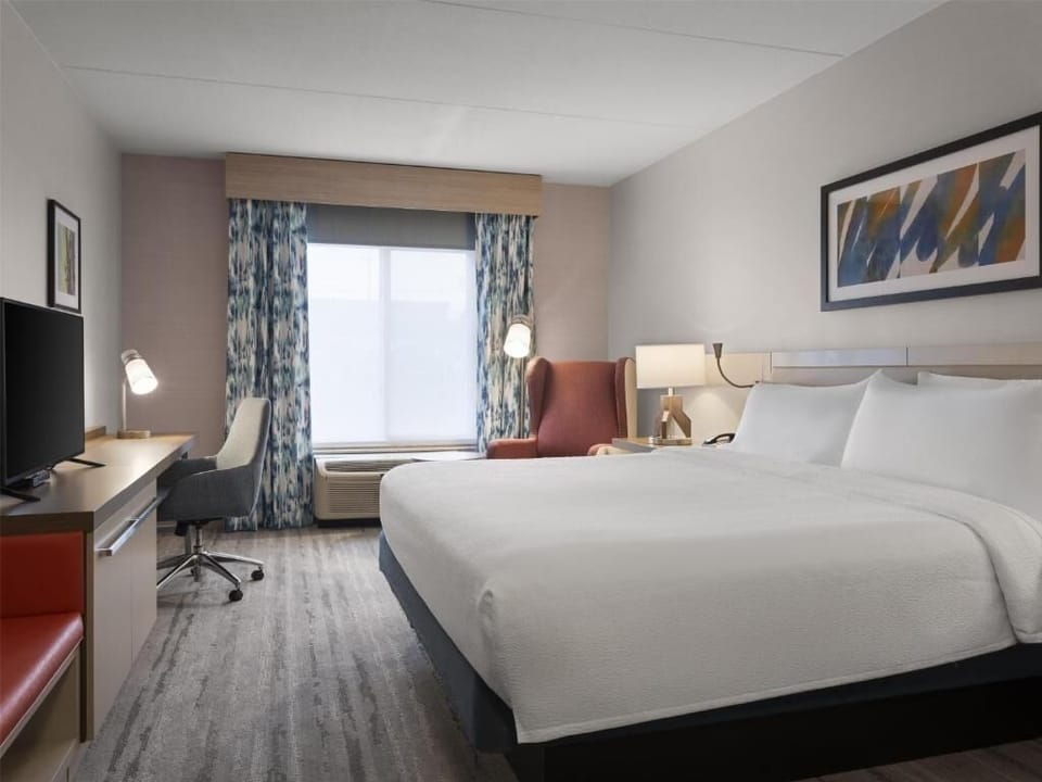 Relax in a spacious, sunlit room with a plush bed.