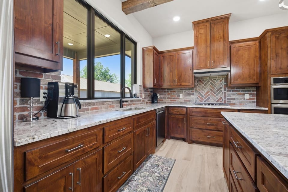 Kitchen with gas burning stove, Microwave, Oven, and coffee maker.
