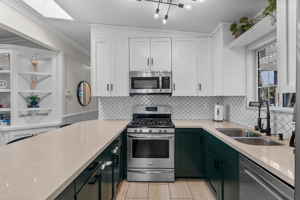 Elegant kitchen with stainless appliances and sleek two-tone cabinets.