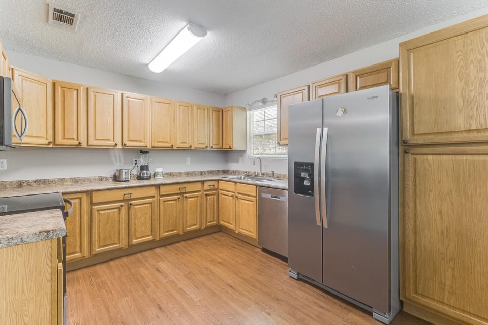 Enjoy the convenience of a roomy kitchen with abundant storage and wood cabinetry.