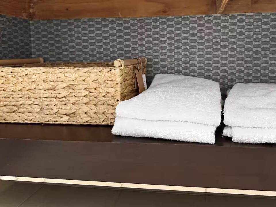 Fresh white towels with woven basket add spa-like comfort & organization