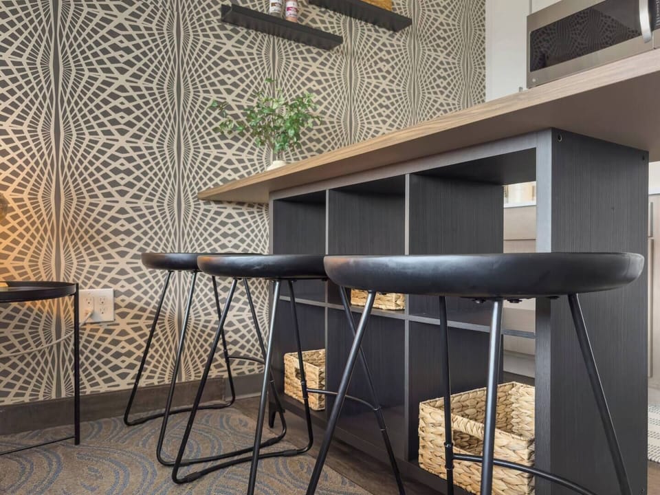 Chic breakfast bar with black stools, basket storage & geometric accent wall
