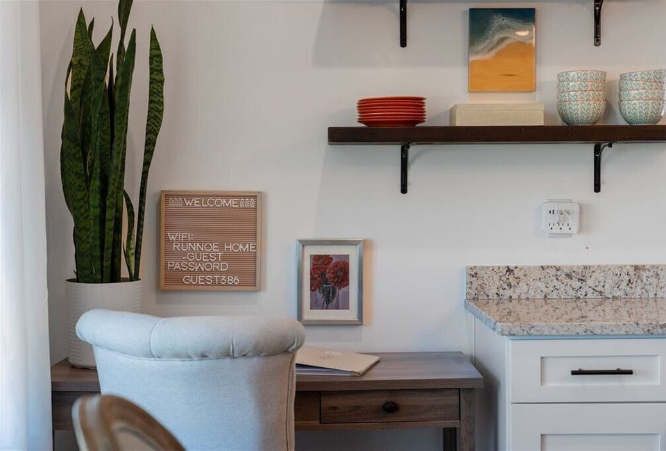 Cozy corner with a desk, chair, and decorative shelves.