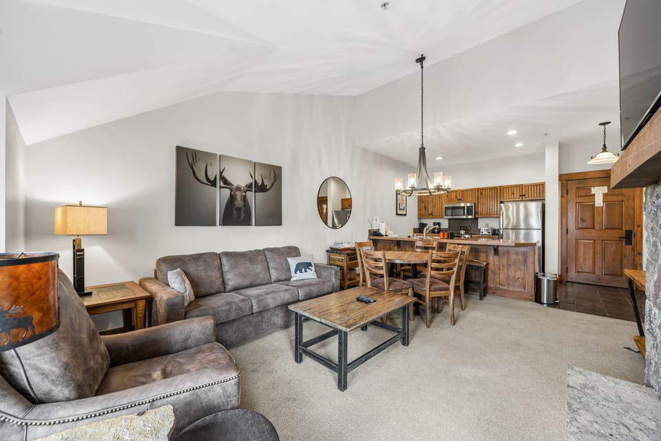 Great room with stone hearth and antler chandelier.