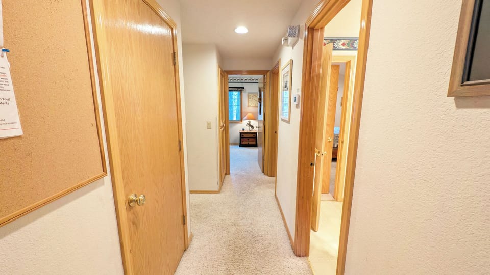 The Hallway -Bath on the right, connects to the Queen Bedroom.  On the left is the Primary Bedroom and ahead the Bunk Room