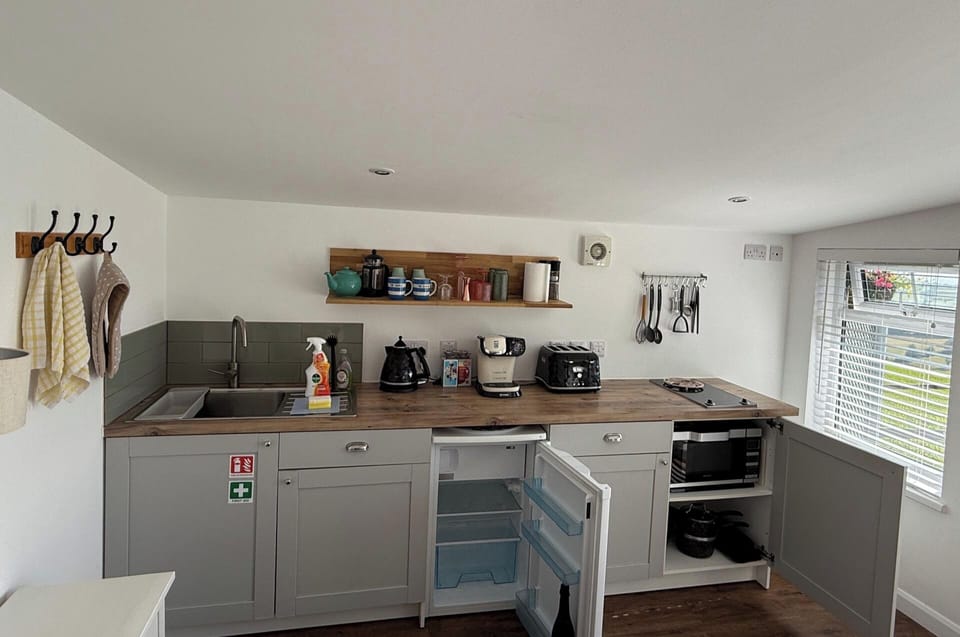 The fitted kitchen area with microwave convection oven and hob, fridge with freezer compartment, toaster, coffee maker and all the tableware, drinking ware and cookware you'll need