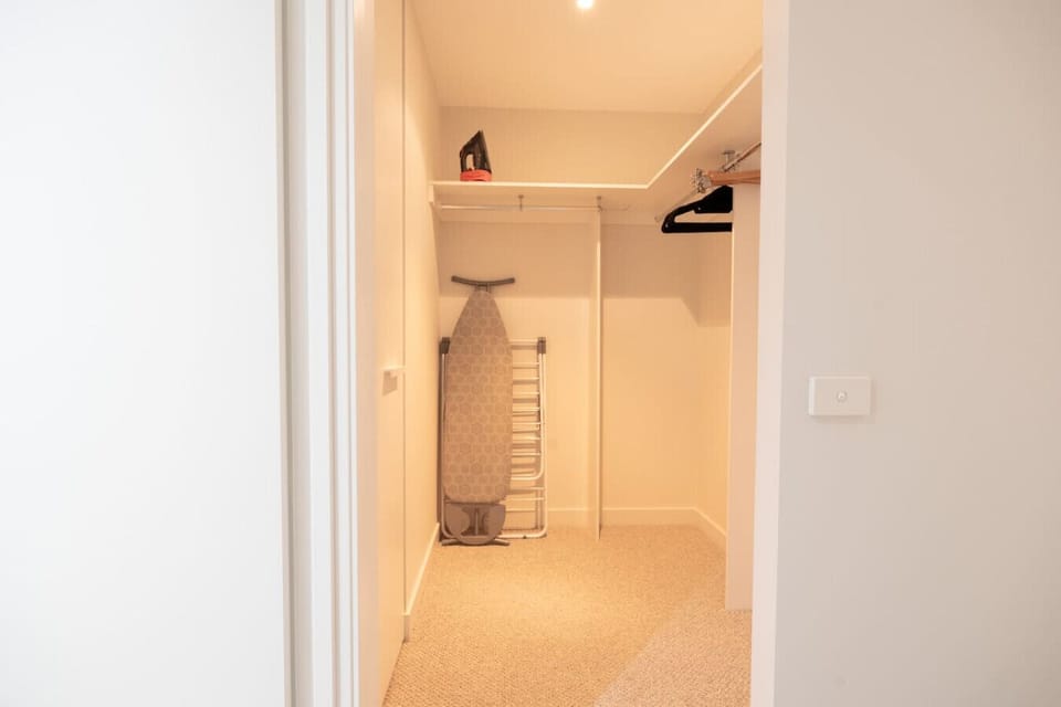 Storage room with iron and ironing board
