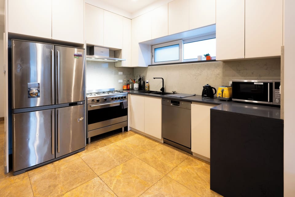 Fully equipped kitchen feature a large double-door fridge, gas stovetop & oven