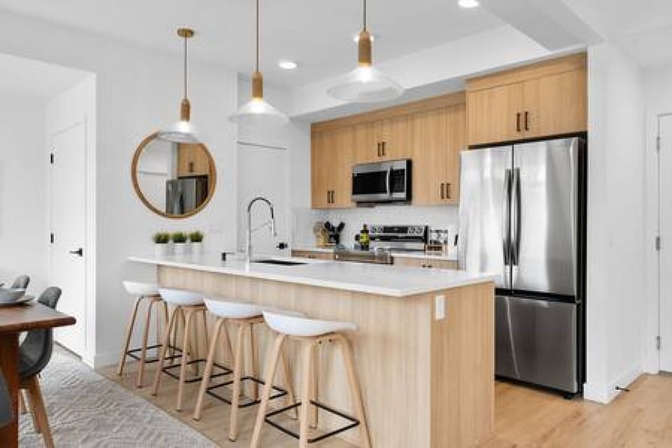 Stylish kitchen with white quartz countertops and large kitchen island with seating for 4 (bar stools), all essentials are provided