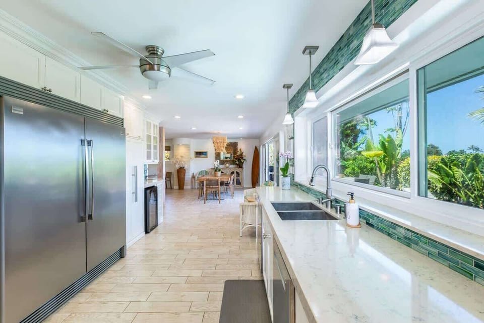 A modern kitchen made for gathering—fully equipped with premium appliances and ocean views to match