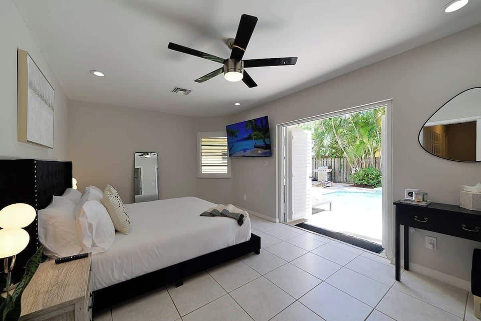 Unit 4 master bedroom with king bed and en suite bathroom. This bedroom features french doors opening to the pool area. This unit has 3 bedrooms and 2 bathrooms