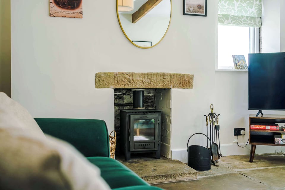 Relax in this stylish living room in the heart of Haworth. With rustic beams, velvet sofas, and a smart TV, it’s the perfect mix of charm and comfort. Large windows offer lovely views, filling the space with light and showcasing the fabulous views.