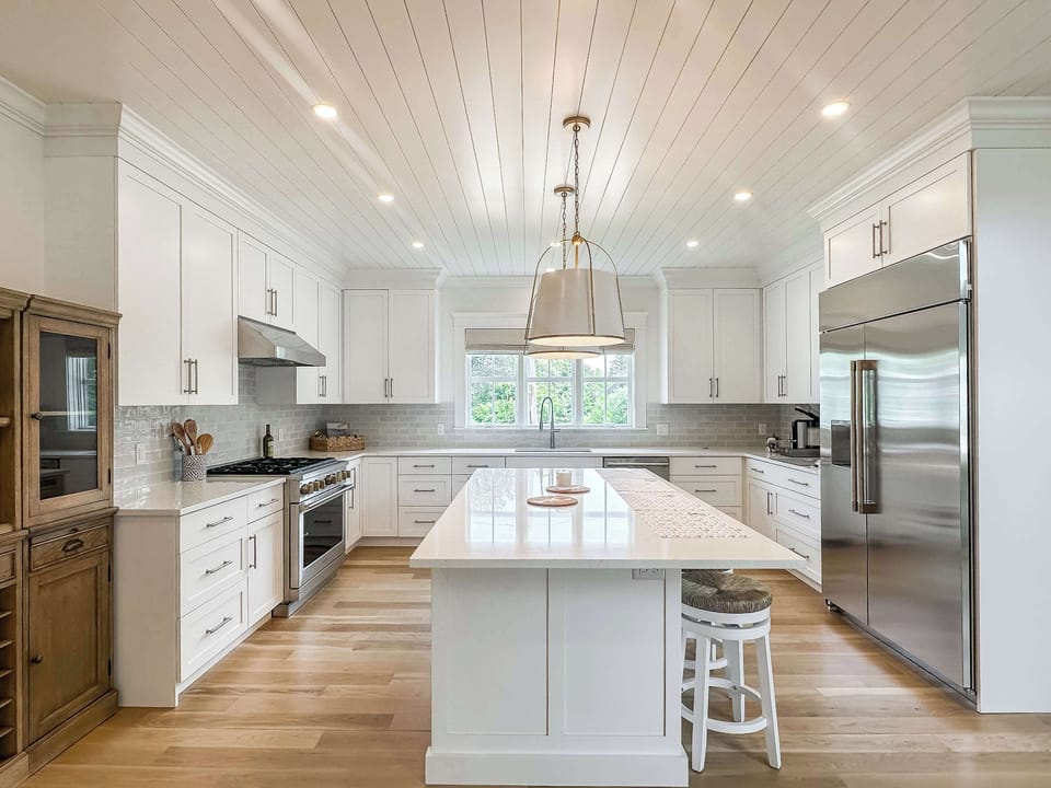 Chef's kitchen with countertop seating, espresso machine and luxury appliances.