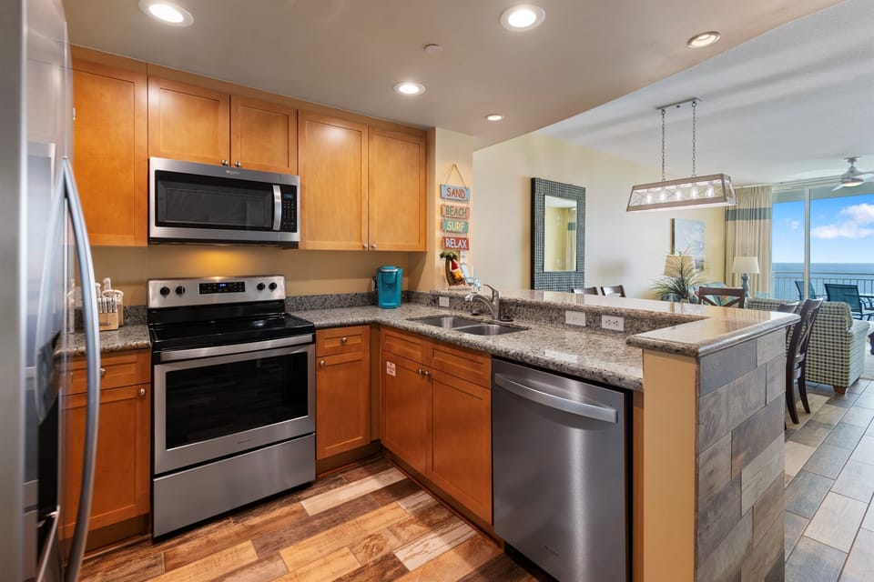 Your fully equipped kitchen features granite counters, stainless appliances, and opens to ocean views—perfect for your morning coffee routine.