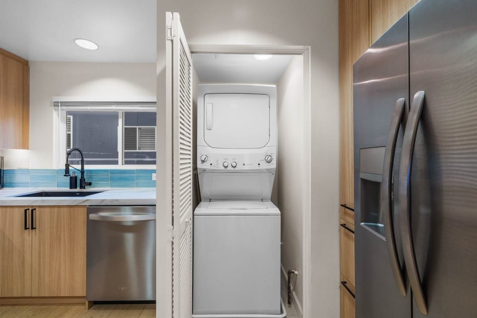 An in-unit stacked washer and dryer, tucked neatly off the kitchen
