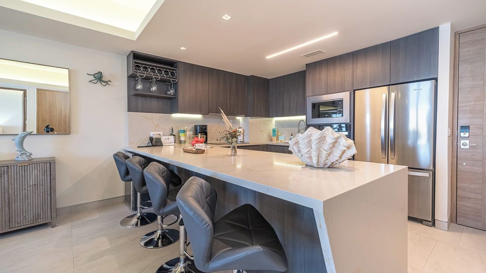 The large modern kitchen with stainless steel appliance and upholstered bar stools