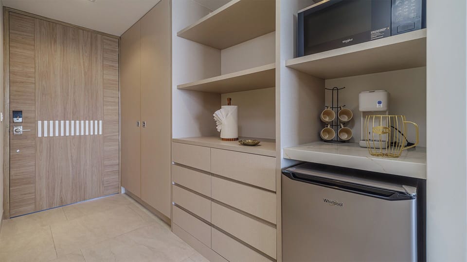 The kitchenette area offering refrigerator, coffee maker, and microwave oven