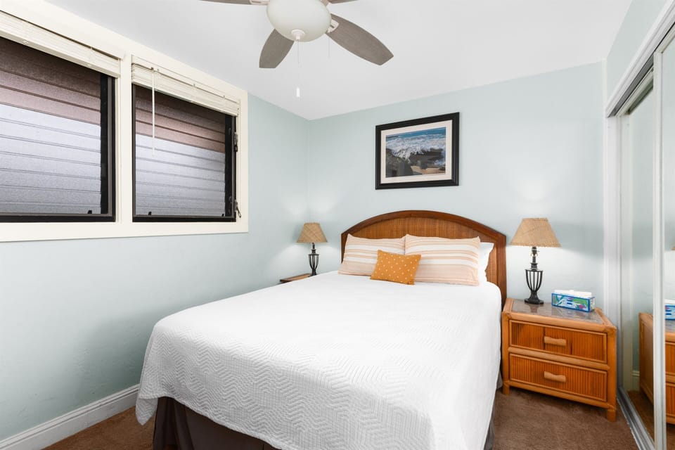 Guest bedroom has a queen bed and is located close to the entry and kitchen.