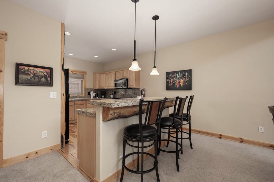 Your fully-equipped kitchen features granite counters, modern appliances, and a welcoming breakfast bar where you can enjoy morning coffee or evening snacks together.