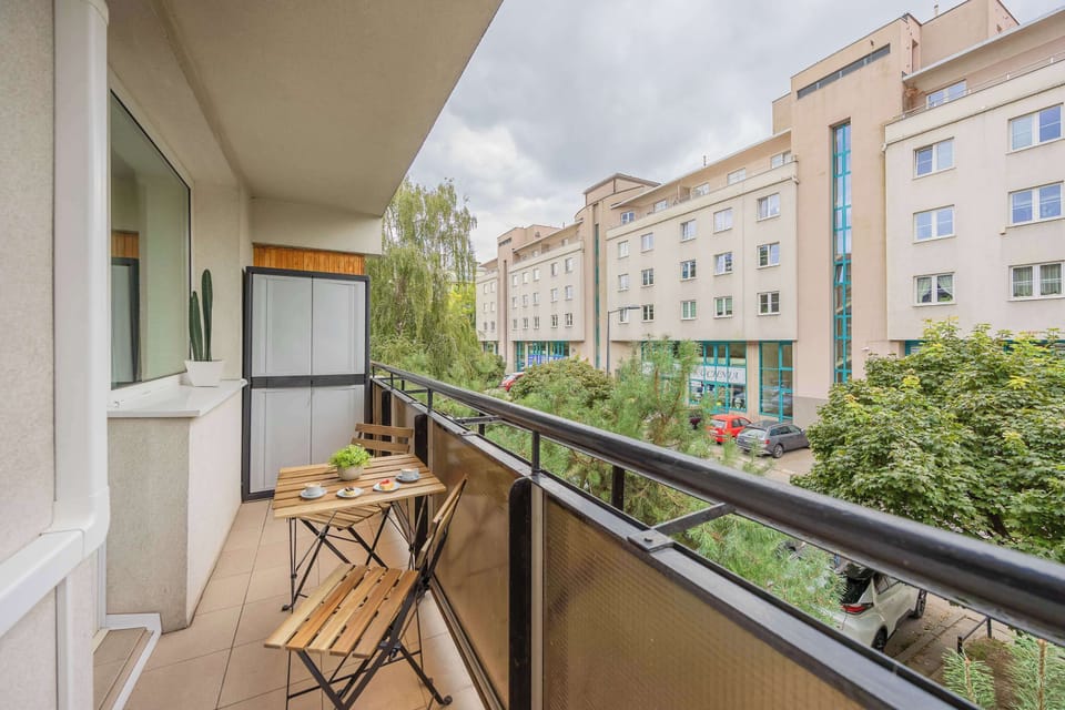 The balcony with a view of greenery and comfortable chairs is perfect for enjoying your morning coffee outdoors.