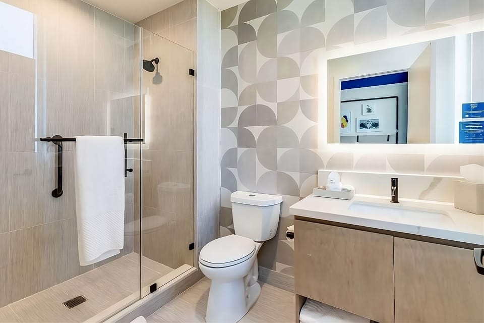 Refresh under a sleek glass shower in a spotless modern bath.