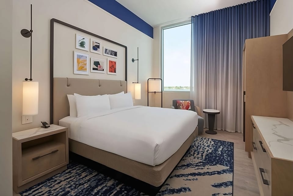 Drift off in a quiet king bed framed by soft curtains.