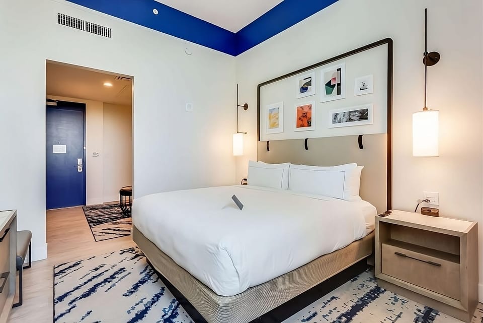 Unwind in crisp linens beneath calming blue accents and art.