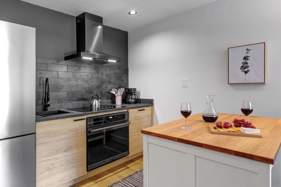 The well-equipped kitchen with new light wood cabinets and black finishes.