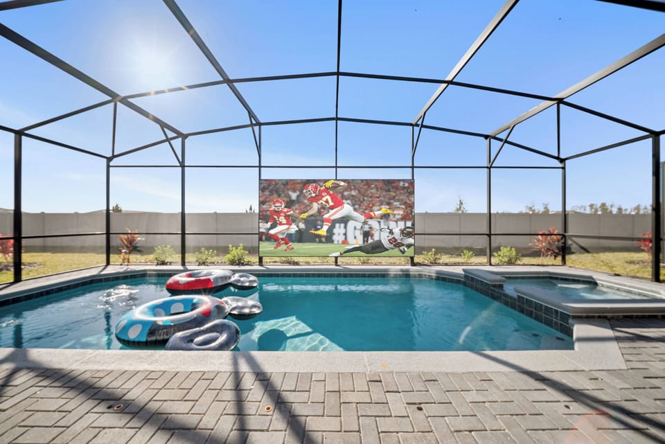 Discover a vibrant outdoor oasis with a crystal-clear pool and a sleek screened enclosure. Relax on colorful floaties under the bright blue sky, enjoying a playful mural that enhances your retreat experience.