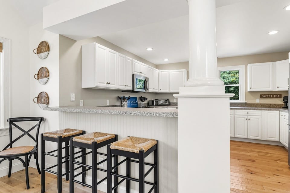 The kitchen includes counter seating, double ovens, and modern appliances, making meal prep effortless for large families or groups.