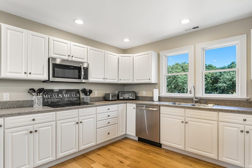 The kitchen includes counter seating, double ovens, and modern appliances, making meal prep effortless for large families or groups.