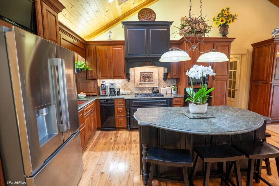 Modern kitchen featuring granite counters, stainless steel appliances, and cozy bar seating.