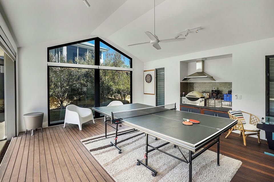 Inside/outside games room including dart board/ping pong and gaming machine and weber BBQ.