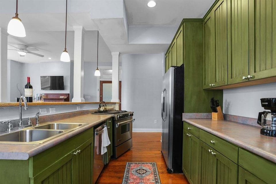 A kitchen made to impress—with sage green cabinets and a large island.