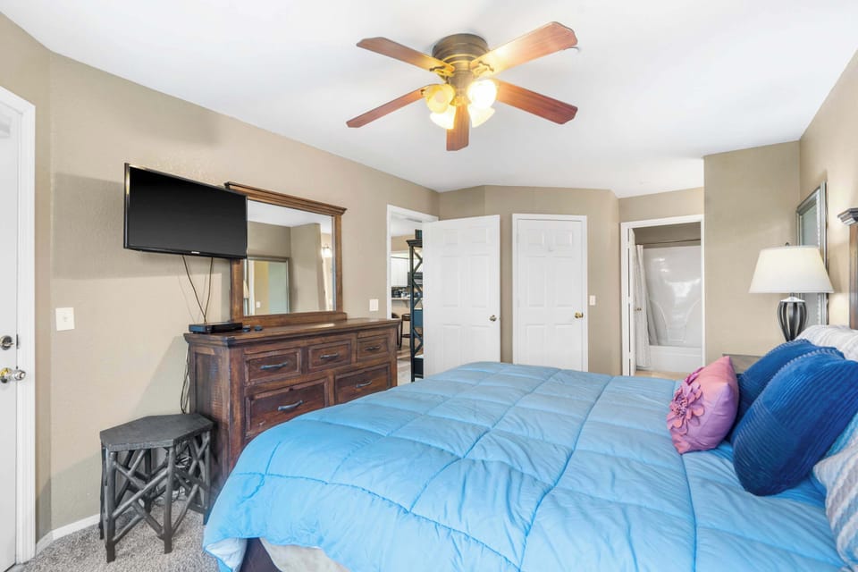 The primary king suite boasts a TV, an ensuite bath, & deck access​