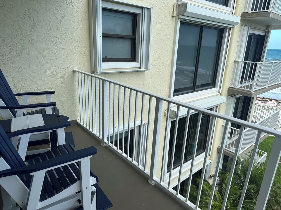 Gliding chairs on outdoor balcony overlooking the ocean