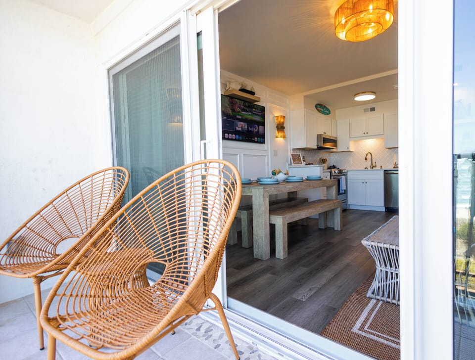 Sunny balcony + coastal kitchen with farmhouse table and modern comforts