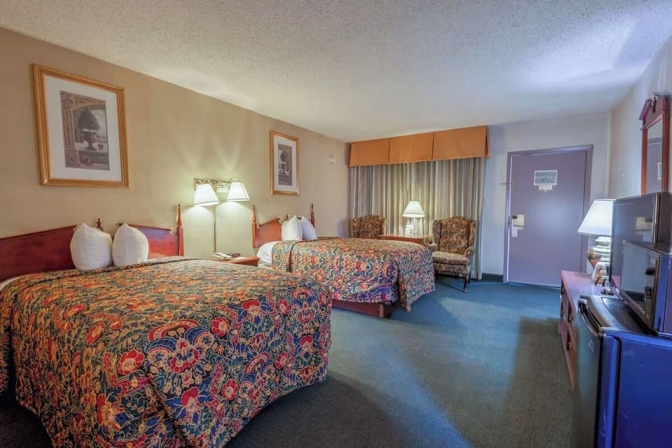 Unwind in a spacious double-queen room with warm lighting.