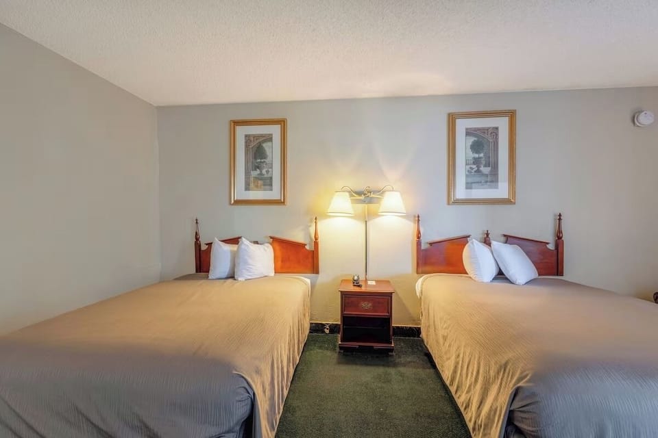 Sink into plush comfort with two beds and warm ambient light.