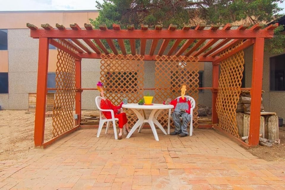 Unwind outdoors under the pergola with casual seating.