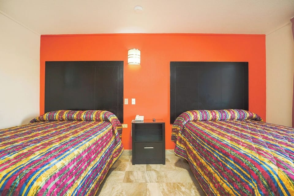 Unwind together with side-by-side beds and warm lighting.
