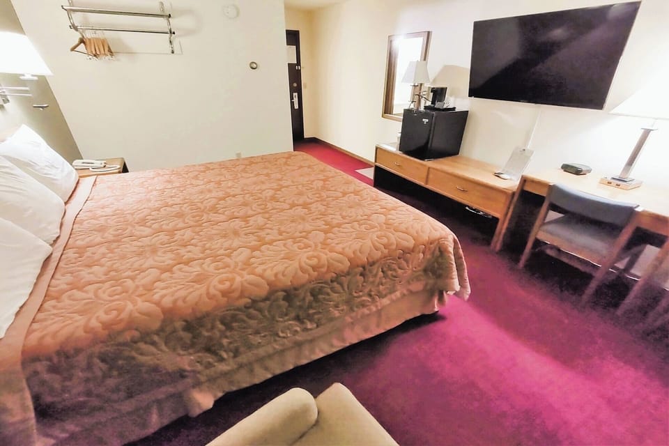 Unwind in a cozy king bed with desk and TV.