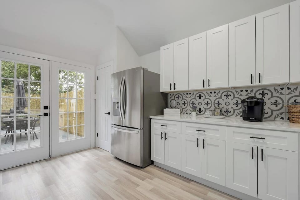 Bright kitchen space with French doors and full-size fridge